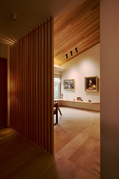 壁には絵、下の棚板には器、床はヘリンボーン張りのリビング