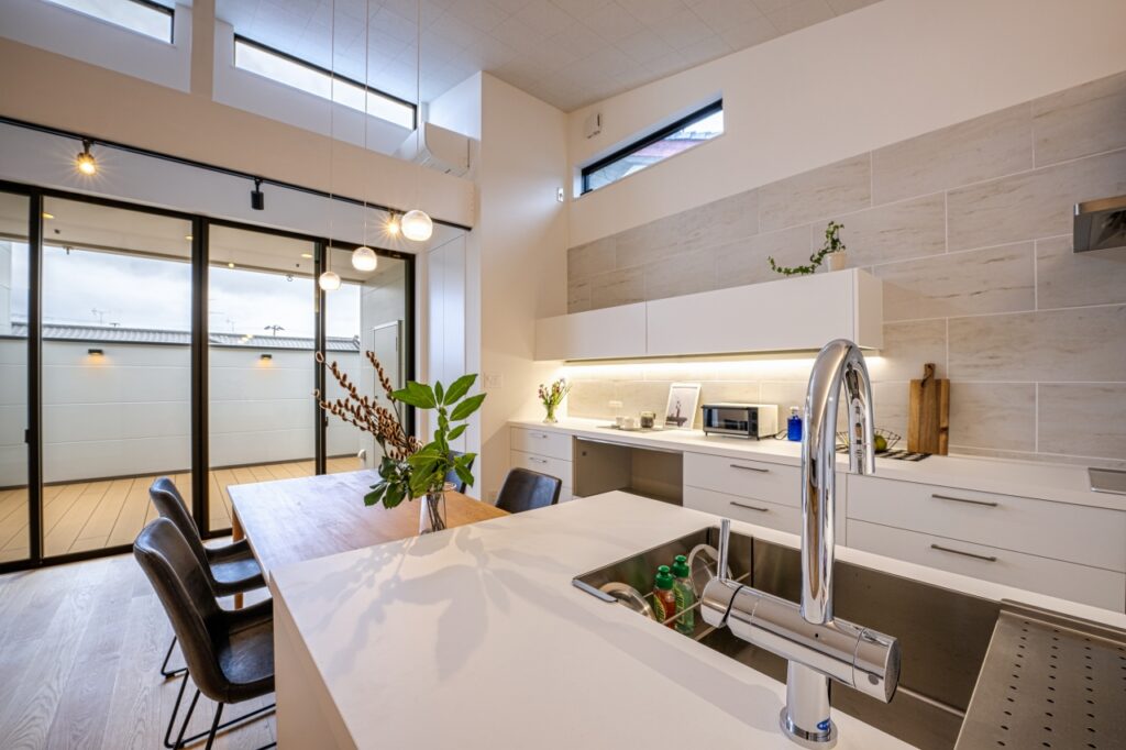 こだわりの白で揃えたキッチンとタイル壁