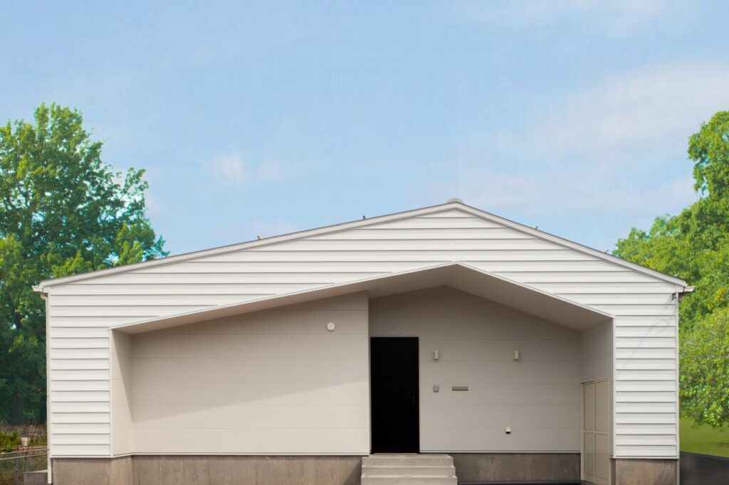 白を基調とした外観。玄関ドアの黒がアクセント