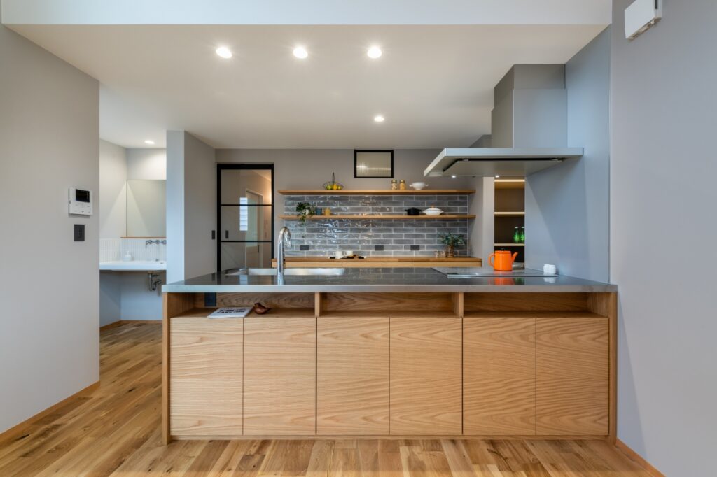 木製の造作キッチンとグレータイルがアクセントの背面収納
