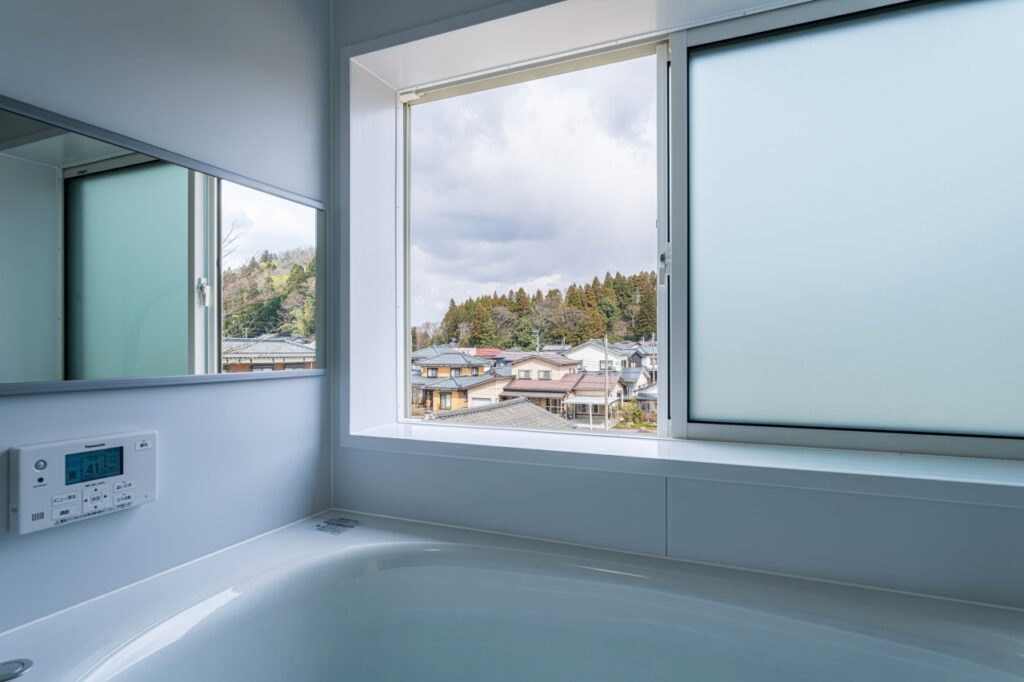 できるだけ低く設置した大きな窓を開けると半露天風呂のように入浴できるお風呂