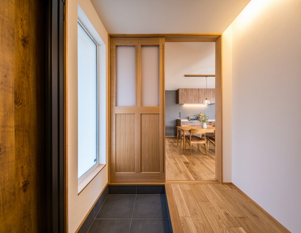 玄関からLDKへ繋がる扉は格子窓でデザイン