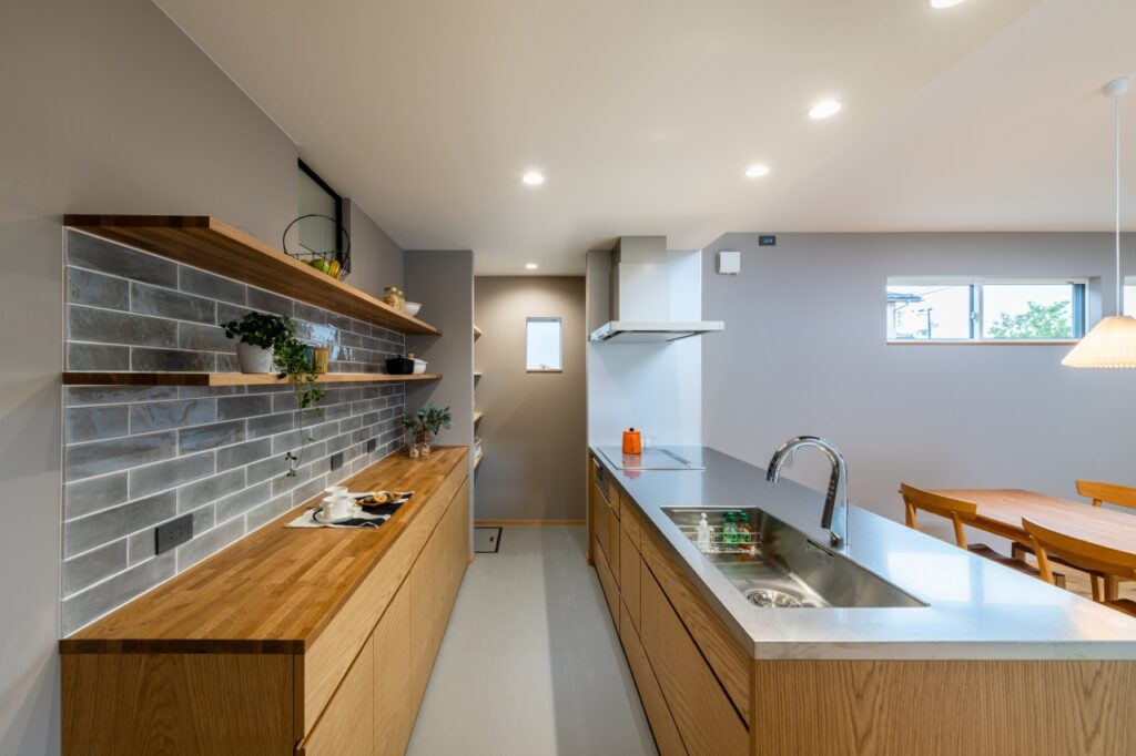 木製の造作キッチンとグレータイルがアクセントの背面収納