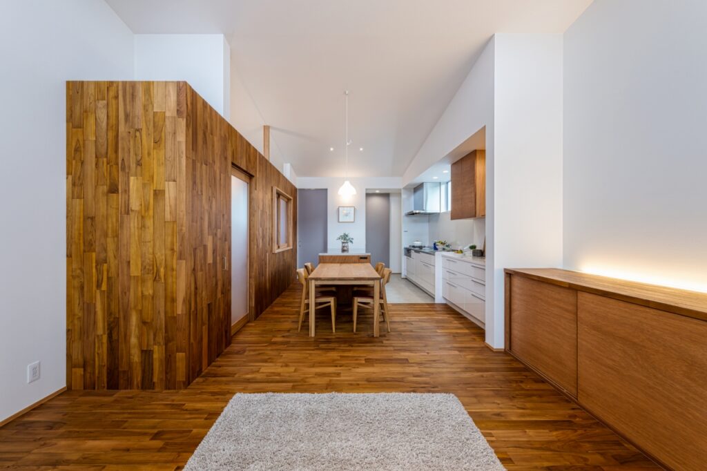 壁面までチークの床材を張り上げ、つながりのある空間にしたLDK