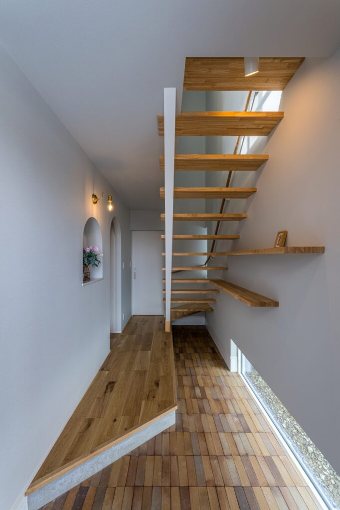 タイルの床とスケルトン階段が印象的な玄関ホール